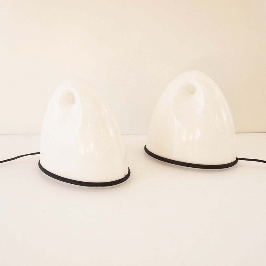 Pair of table lamps designed by Bruno Gecchelin for Guzzini during the 1980's. White plastic with a rubber band that allows the closure of the lamp which is divided into 2 parts. -  Paire de lampe de table dessinées par Bruno Gecchelin pour Guzzini dans les années 80. Plastique blanc avec une bande de caoutchouc qui permet la fermeture de la lampe qui est scindée en 2 parties