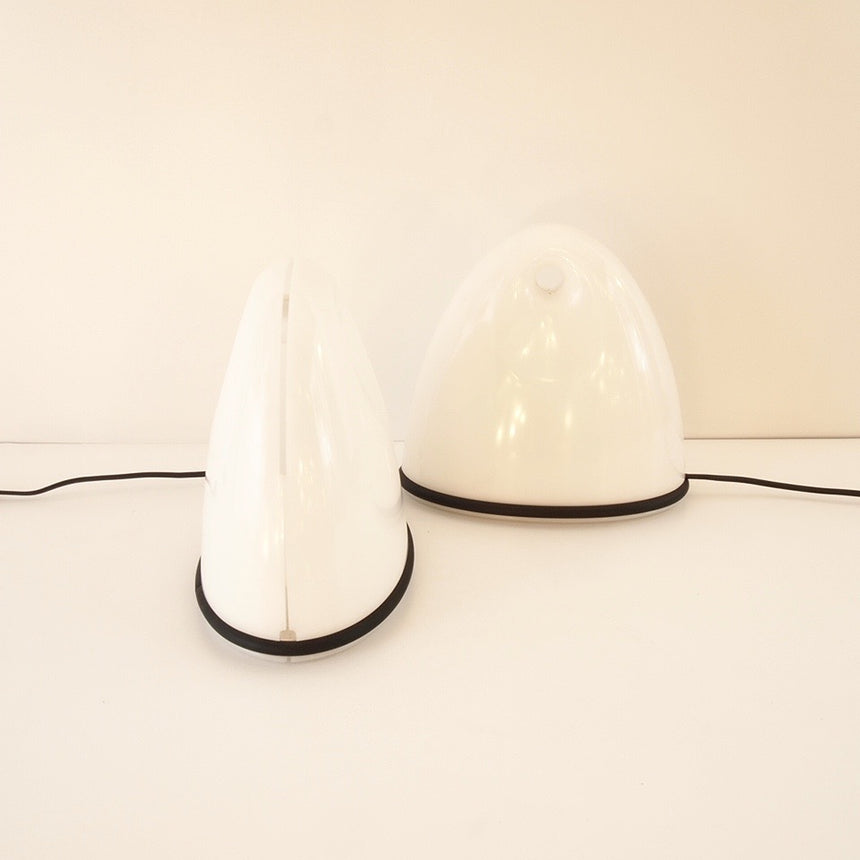 Pair of table lamps designed by Bruno Gecchelin for Guzzini during the 1980's. White plastic with a rubber band that allows the closure of the lamp which is divided into 2 parts. -  Paire de lampe de table dessinées par Bruno Gecchelin pour Guzzini dans les années 80. Plastique blanc avec une bande de caoutchouc qui permet la fermeture de la lampe qui est scindée en 2 parties