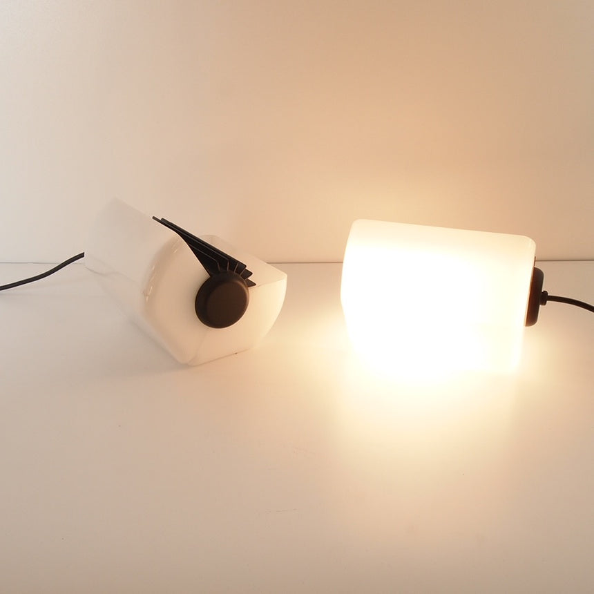 Pair of table lamps designed by Bruno Gecchelin for Guzzini during the 1980's. White plastic with a rubber band that allows the closure of the lamp which is divided into 2 parts. -  Paire de lampe de table dessinées par Bruno Gecchelin pour Guzzini dans les années 80. Plastique blanc avec une bande de caoutchouc qui permet la fermeture de la lampe qui est scindée en 2 parties