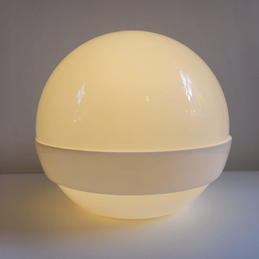 Shop online / The Globe table lamp designed by André Ricard for Metalarte during de 1970's, is made of two half globes in white acrylic shell. Acheter en ligne / La lampe de table Globe a été conçue par André Ricard pour Metalarte dans les années 70. La lampe est composée de deux demi-globes en acrylique blanc.