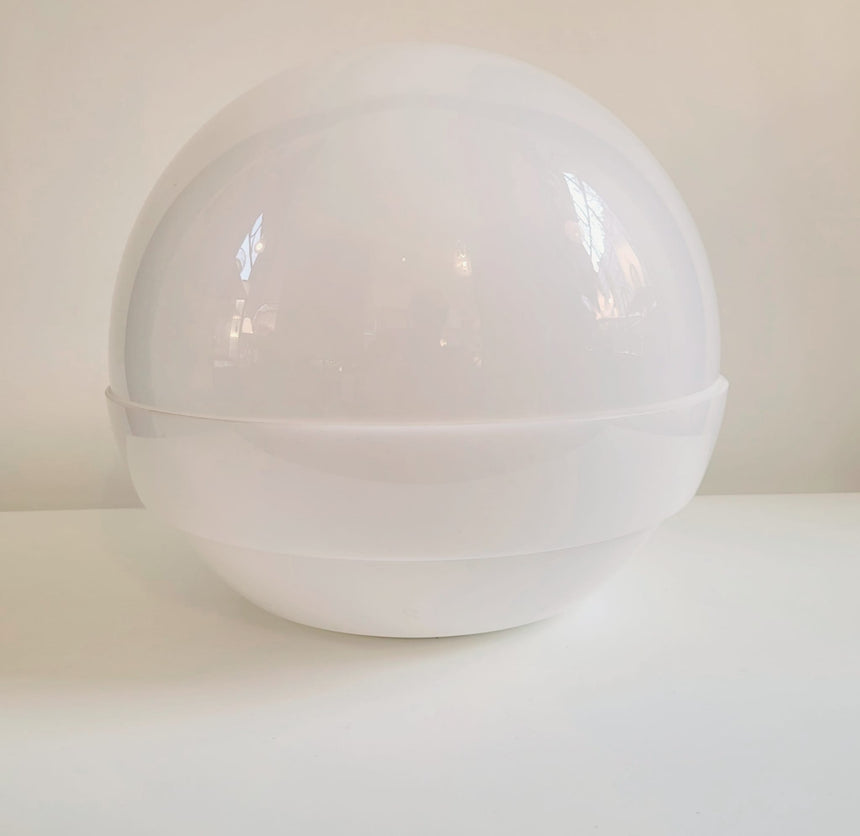 Shop online / The Globe table lamp designed by André Ricard for Metalarte during de 1970's, is made of two half globes in white acrylic shell. Acheter en ligne / La lampe de table Globe a été conçue par André Ricard pour Metalarte dans les années 70. La lampe est composée de deux demi-globes en acrylique blanc.